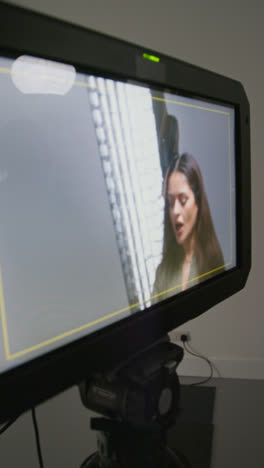 Vídeo-Vertical-De-Una-Directora-De-Cine-Observando-A-Los-Actores-Ensayando-La-Filmación-De-Una-Película-O-Un-Vídeo-En-Un-Estudio-En-Un-Monitor